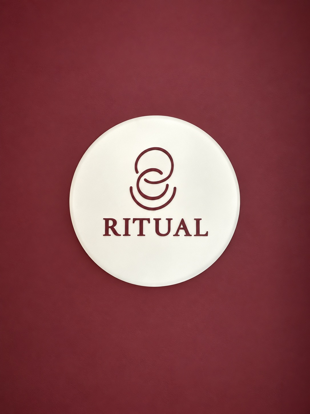 RITUAL's circular logo sign on the café's burgundy wall
